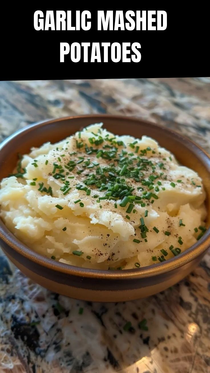 A bowl of creamy garlic mashed potatoes, perfectly smooth and fluffy.