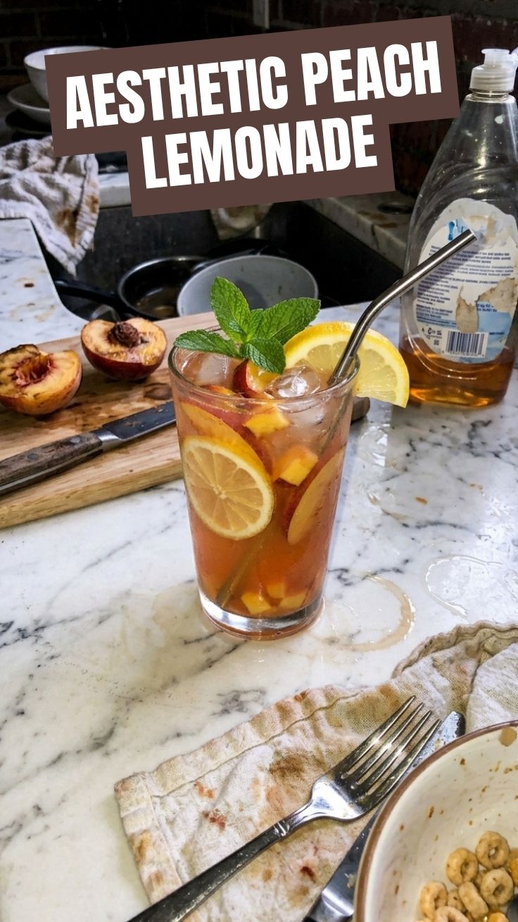 A refreshing glass of peach lemonade with ice and peach slices